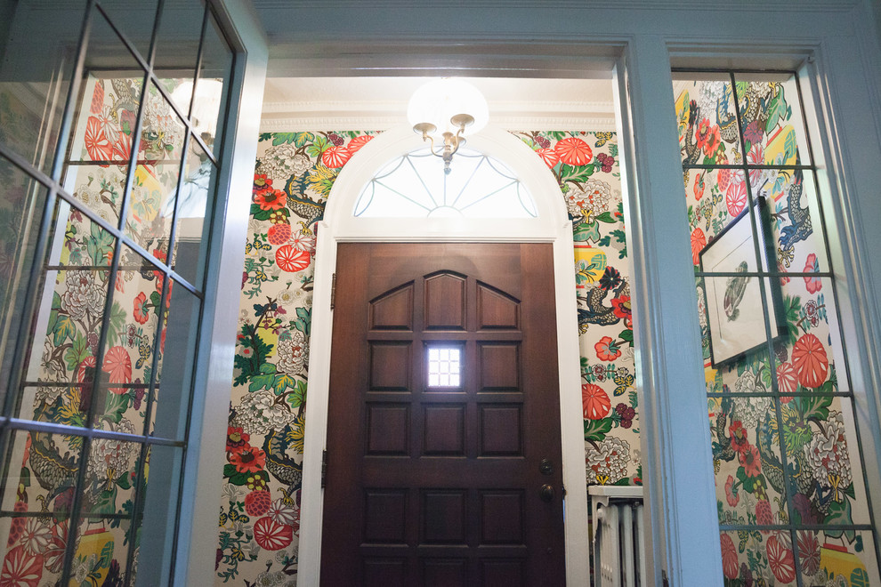 Réalisation d'une entrée tradition de taille moyenne avec un mur multicolore, une porte simple et une porte marron.