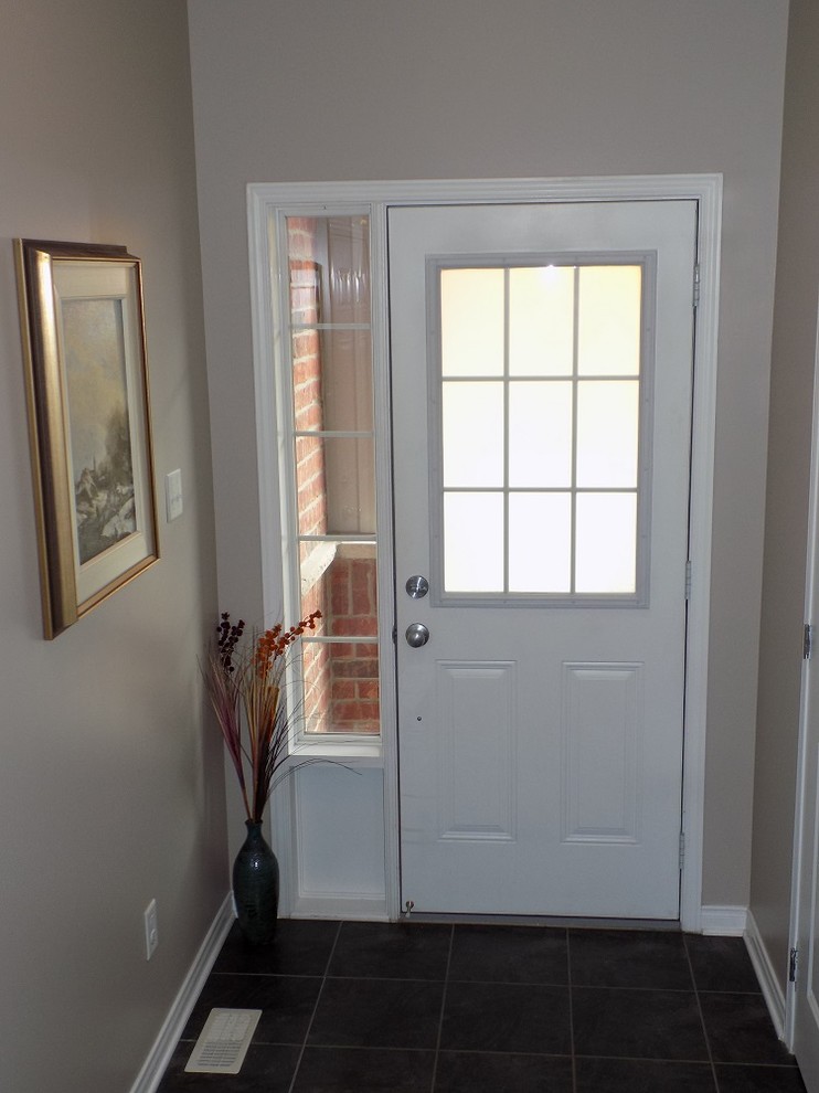 Ispirazione per una piccola porta d'ingresso classica con pareti beige, pavimento in gres porcellanato, una porta singola, una porta bianca e pavimento nero
