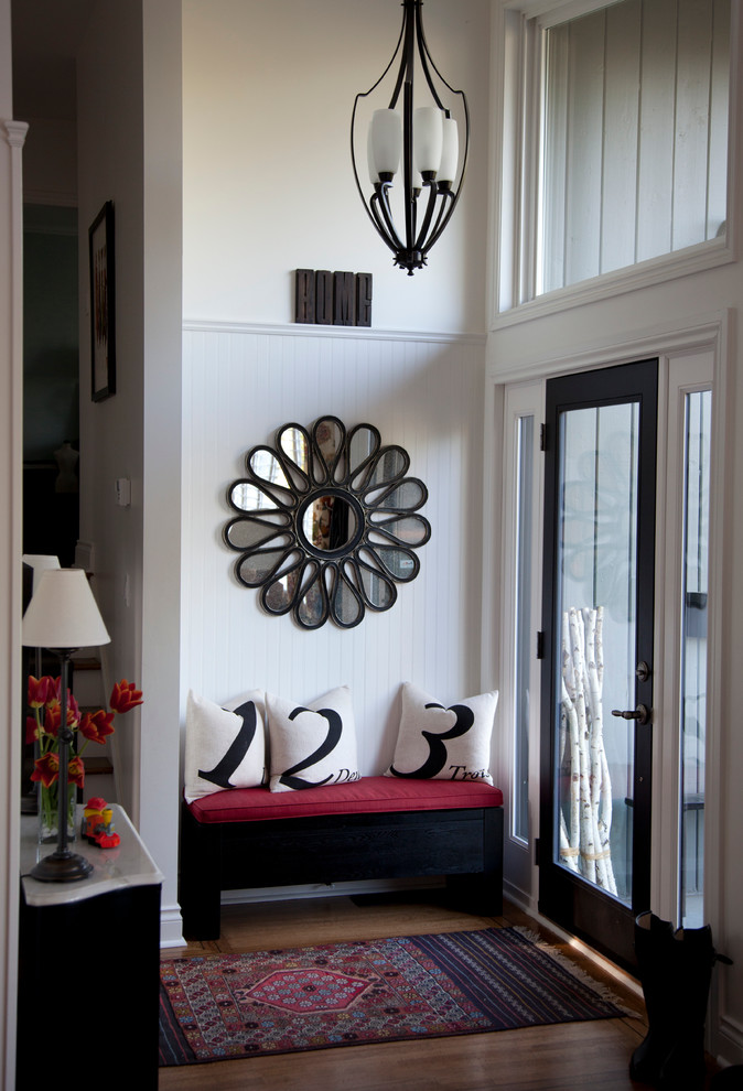 Inspiration for a small timeless medium tone wood floor entryway remodel in Vancouver with white walls and a black front door