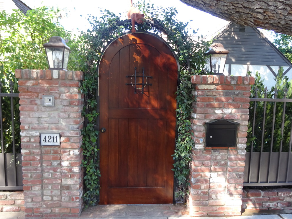 Ispirazione per una porta d'ingresso chic di medie dimensioni con una porta singola e una porta in legno scuro