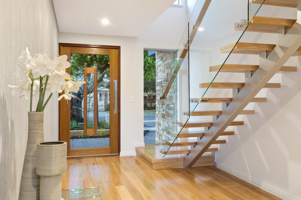 Esempio di un ingresso stile marinaro con pareti bianche, pavimento in legno massello medio, una porta singola, una porta in legno bruno e pavimento beige