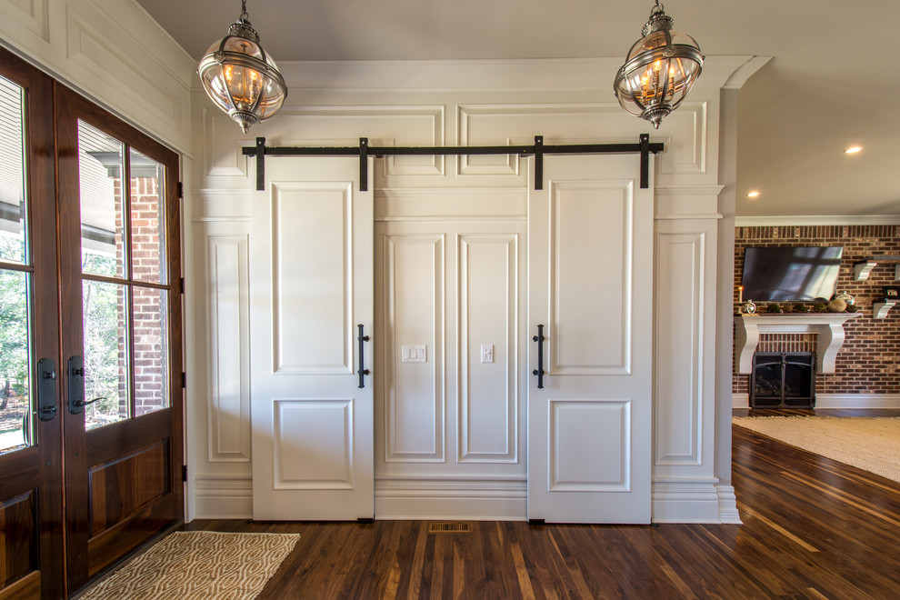 Immagine di un ingresso o corridoio chic di medie dimensioni con pareti bianche, parquet scuro, una porta a due ante e una porta in legno scuro
