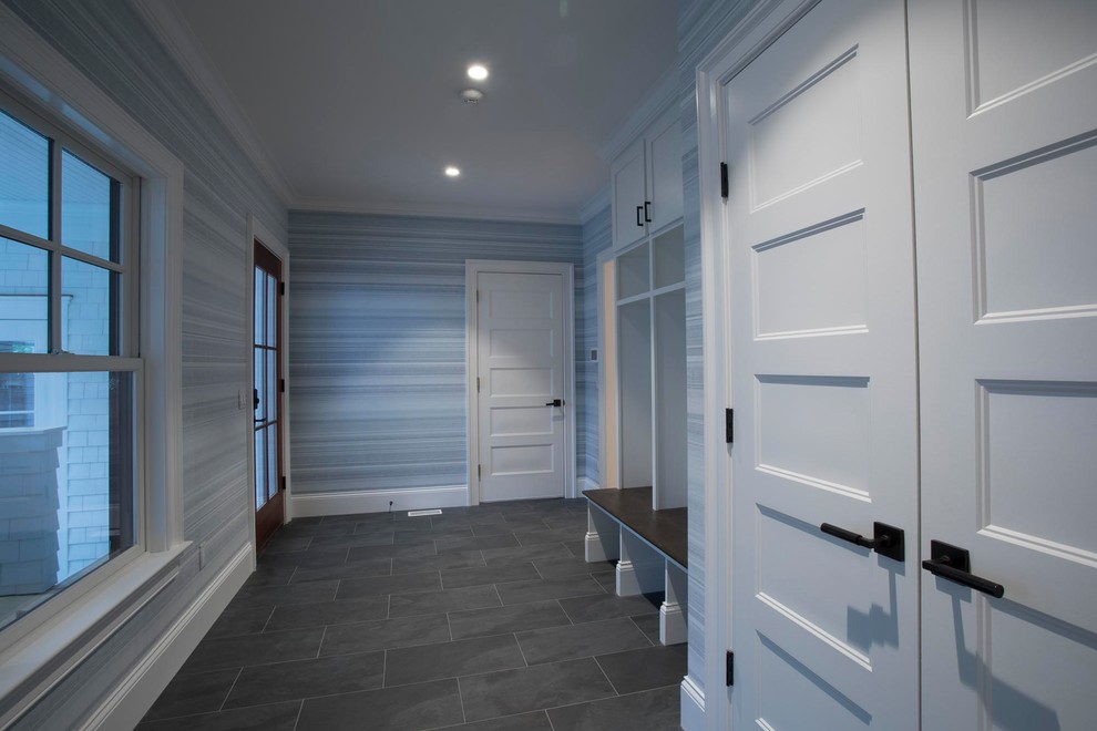 Exemple d'une grande entrée moderne avec un vestiaire, un mur gris, un sol en carrelage de porcelaine et un sol gris.