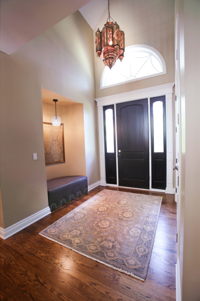 Exempel på en mellanstor klassisk foajé, med beige väggar, mellanmörkt trägolv, en enkeldörr, en brun dörr och brunt golv