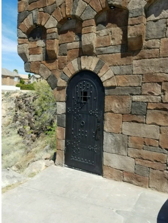Cette image montre une porte d'entrée chalet de taille moyenne avec un mur beige, sol en béton ciré, une porte simple, une porte noire et un sol gris.