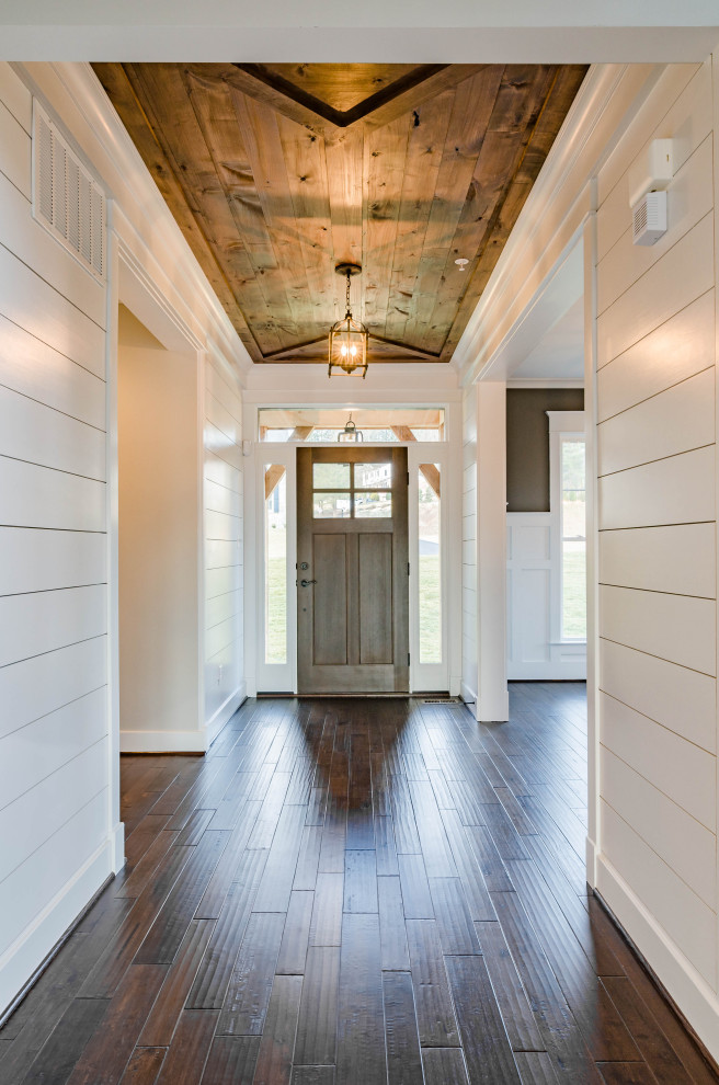 Immagine di un ingresso country con pareti bianche, parquet scuro, una porta singola, una porta in legno bruno, pavimento marrone, soffitto in legno e pareti in perlinato
