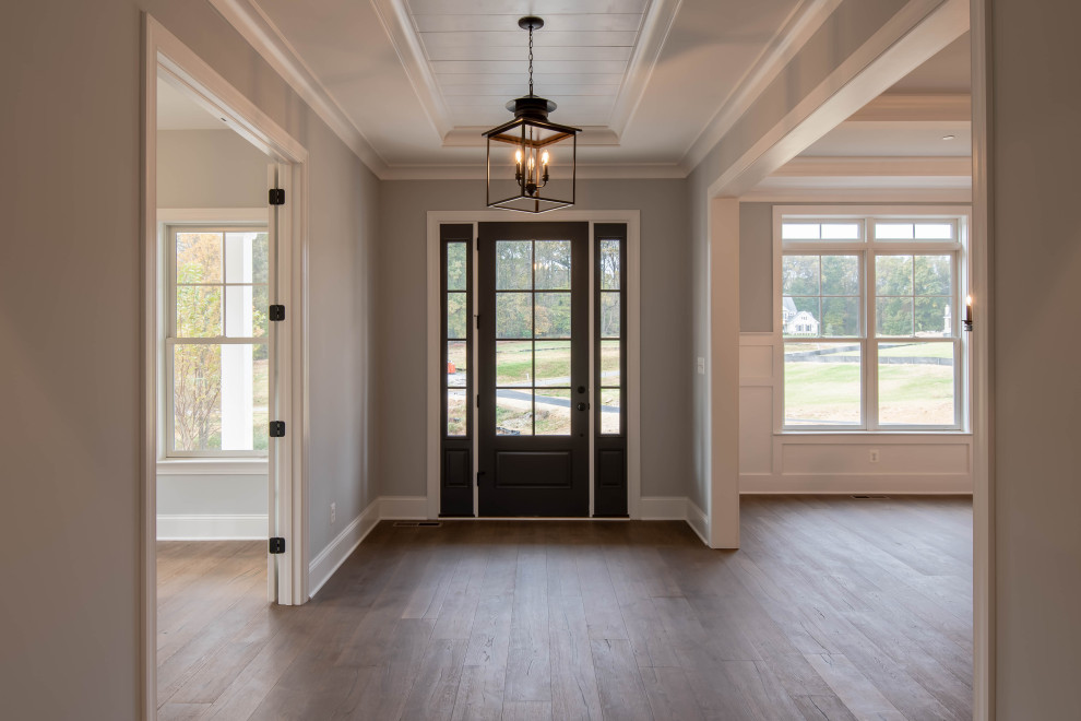 Immagine di un ingresso country con pavimento in legno massello medio, una porta singola, pavimento marrone e soffitto in perlinato