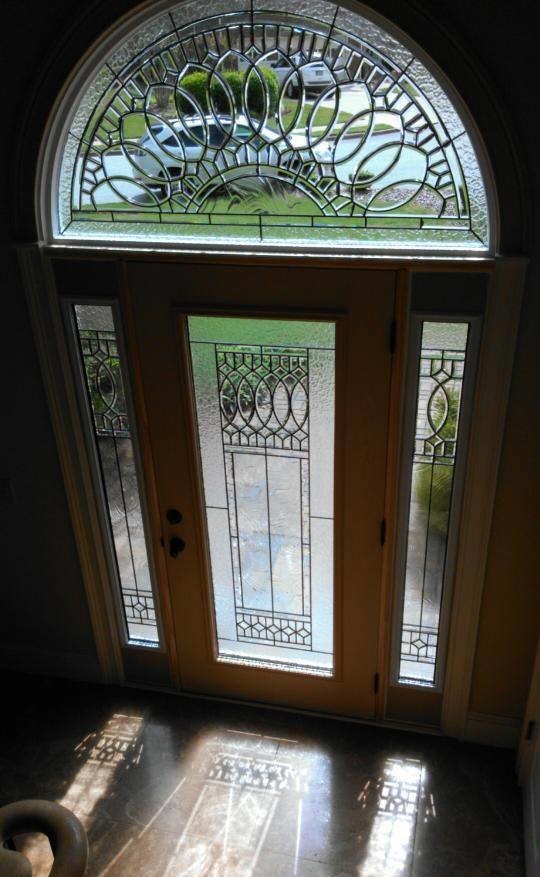 На фото: большая входная дверь в стиле неоклассика (современная классика) с одностворчатой входной дверью и входной дверью из темного дерева с