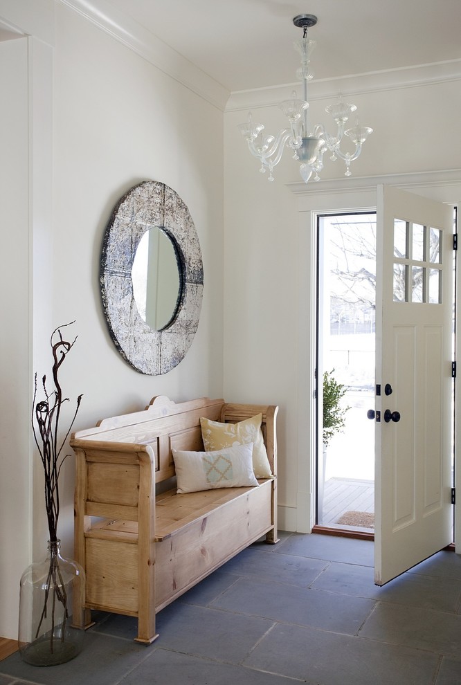Example of a beach style gray floor single front door design in Boston with white walls and a white front door