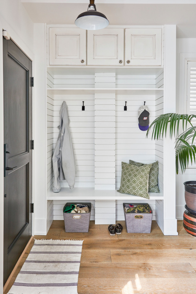 Aménagement d'une petite porte d'entrée contemporaine avec un mur blanc, un sol en bois brun, une porte simple, une porte en bois foncé et du lambris de bois.