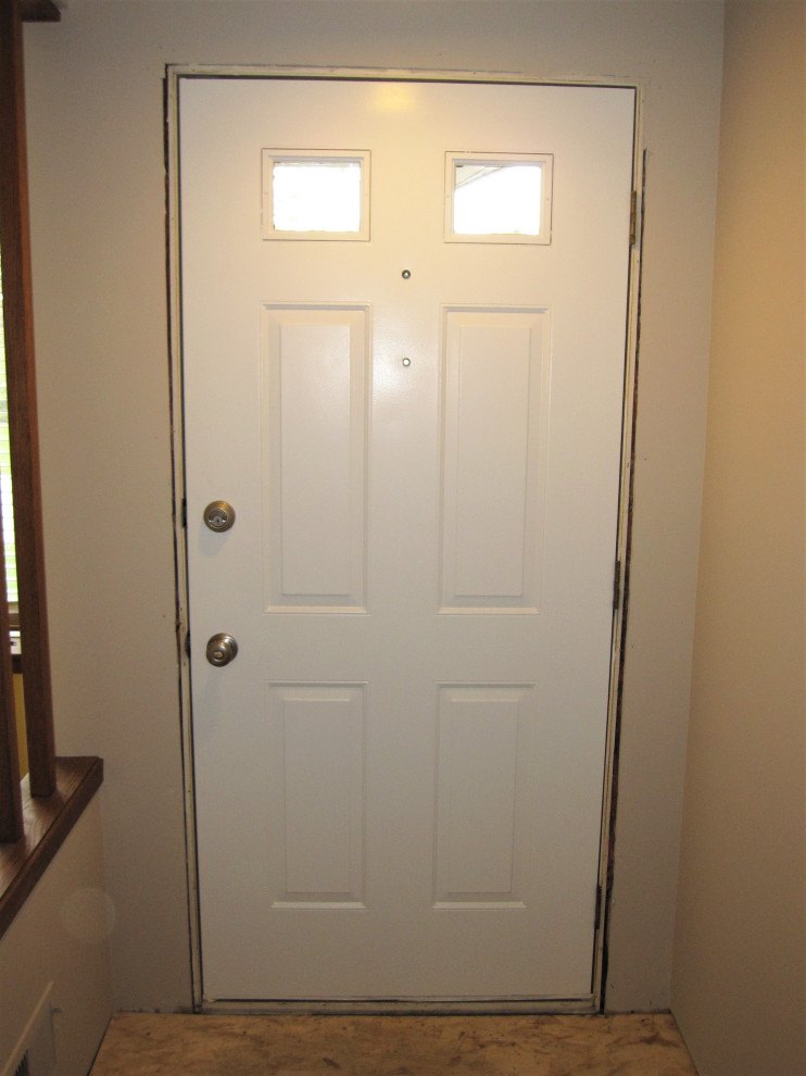 Bild på en stor funkis hall, med beige väggar, en enkeldörr och en vit dörr