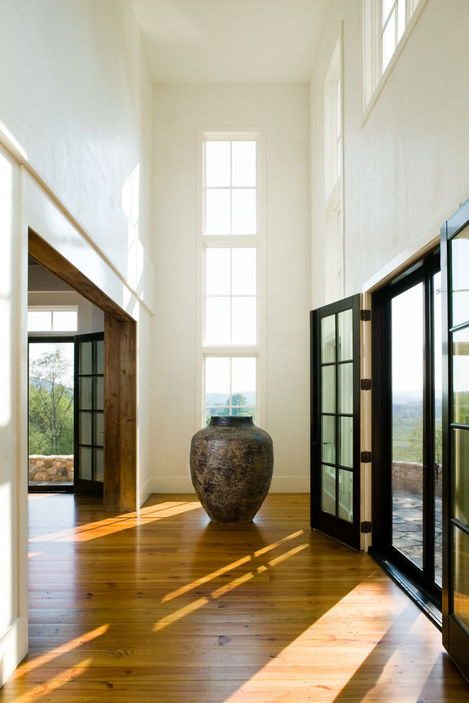Mittelgroßes Landhausstil Foyer mit weißer Wandfarbe, braunem Holzboden, Doppeltür, Haustür aus Glas und braunem Boden in Bridgeport