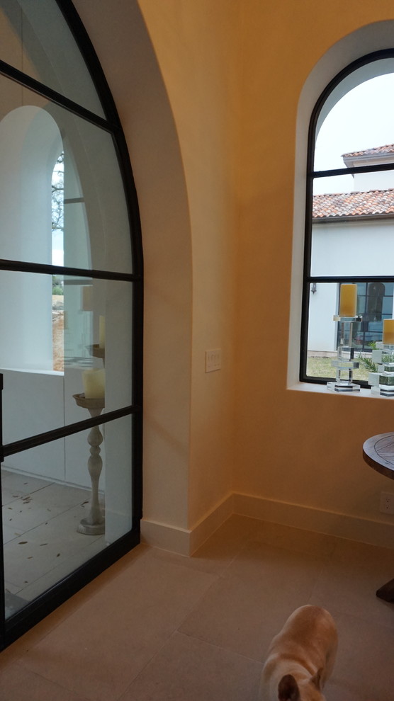 Photo of a large modern vestibule in Houston with white walls, limestone flooring, a single front door and a black front door.
