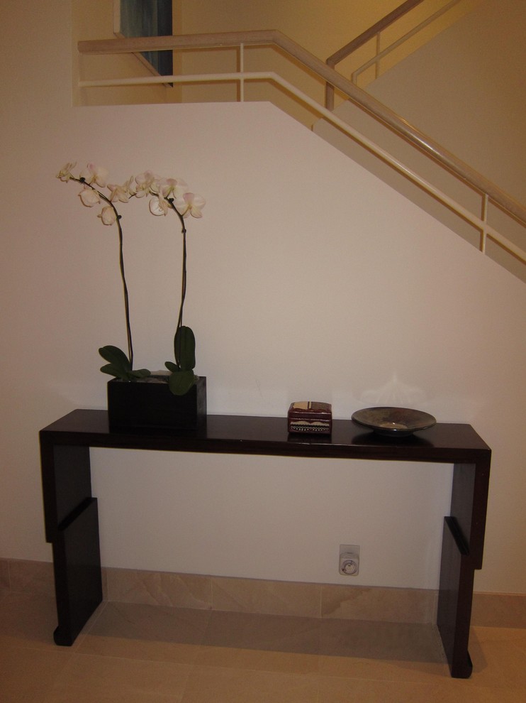 Example of a mid-sized limestone floor foyer design in Los Angeles with white walls