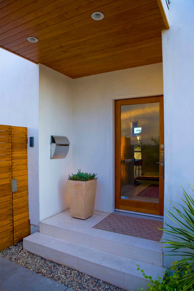 Imagen de puerta principal actual de tamaño medio con puerta de vidrio, paredes blancas, suelo de cemento, puerta simple y suelo gris