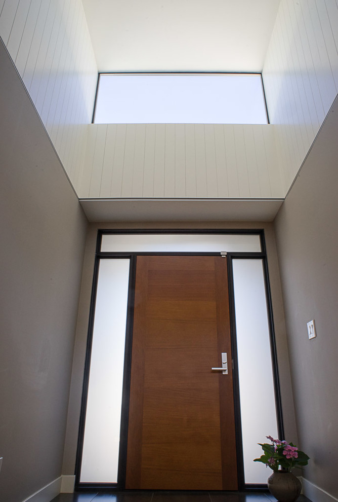 This is an example of a medium sized modern front door in San Francisco with grey walls, a single front door and a dark wood front door.