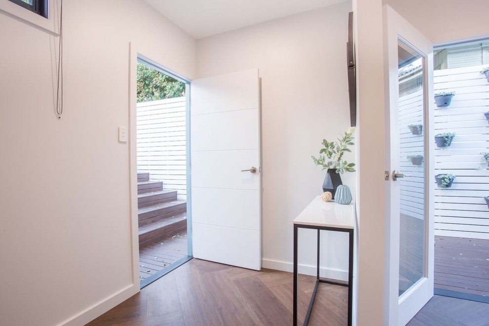 Mid-sized trendy vinyl floor and brown floor entryway photo in Newcastle - Maitland with gray walls and a white front door