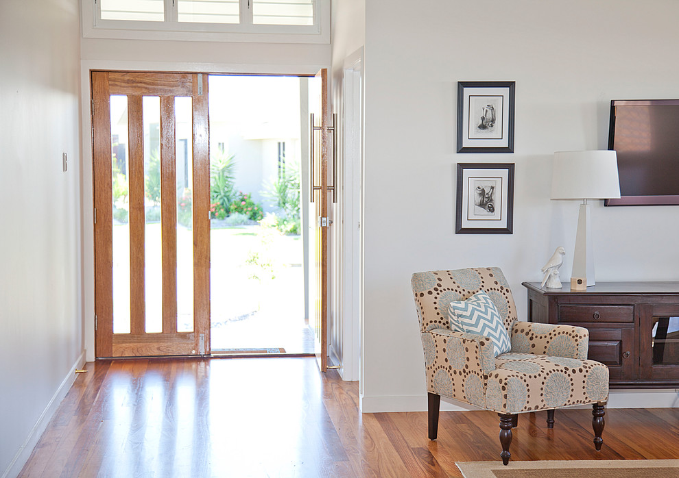 Imagen de entrada costera con suelo de madera en tonos medios y puerta doble
