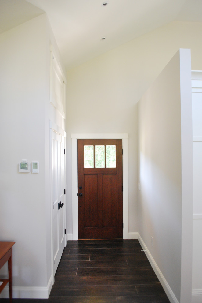 Ispirazione per una grande porta d'ingresso contemporanea con pareti bianche, pavimento con piastrelle in ceramica, una porta singola, una porta in legno scuro e pavimento nero