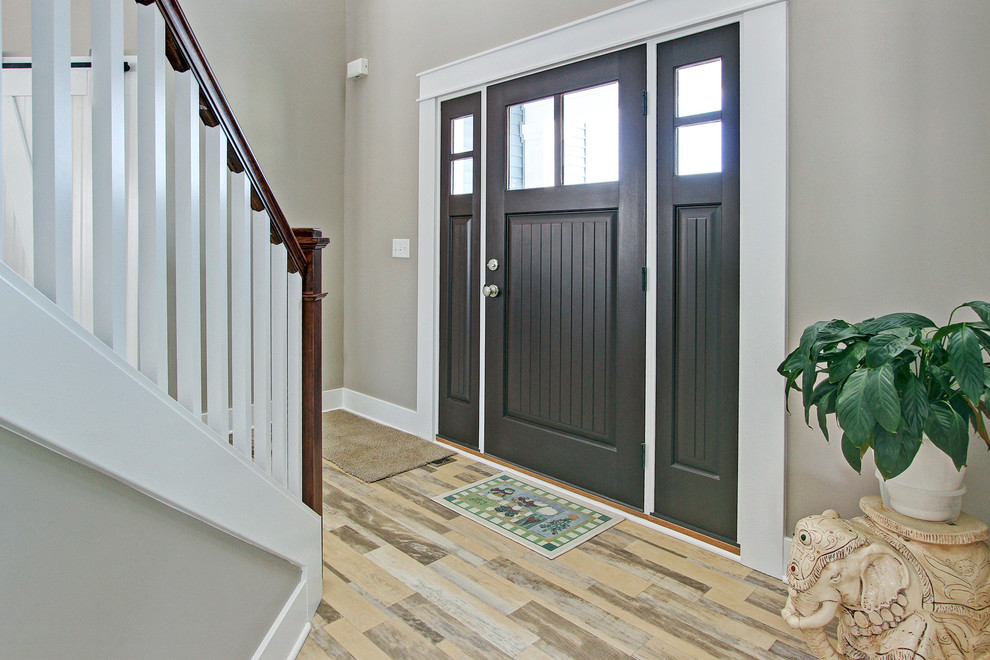 Foto di una porta d'ingresso tradizionale di medie dimensioni con pareti marroni, pavimento in legno massello medio, una porta singola e una porta grigia