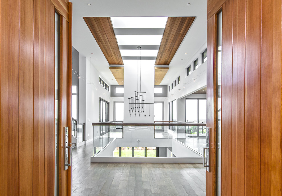 Große Moderne Haustür mit weißer Wandfarbe, hellem Holzboden, Doppeltür, dunkler Holzhaustür und braunem Boden in Seattle