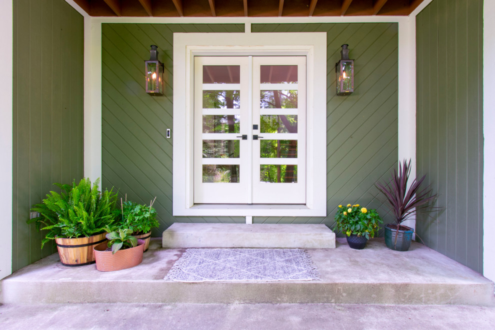 Inspiration för en funkis entré, med gröna väggar, betonggolv, en dubbeldörr och en vit dörr