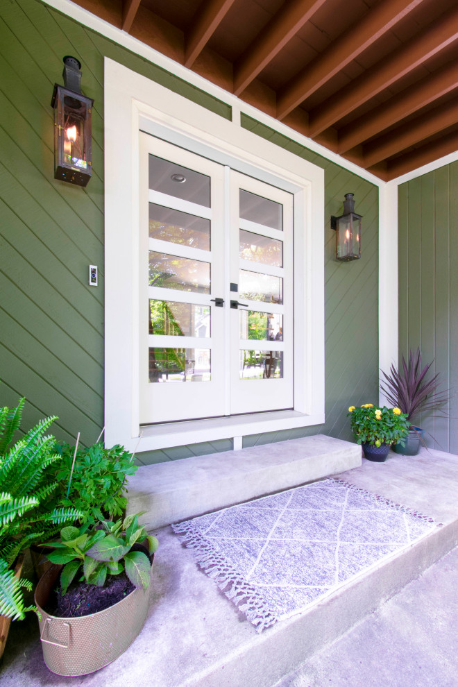 Пример оригинального дизайна: прихожая в современном стиле с зелеными стенами, бетонным полом, двустворчатой входной дверью и белой входной дверью