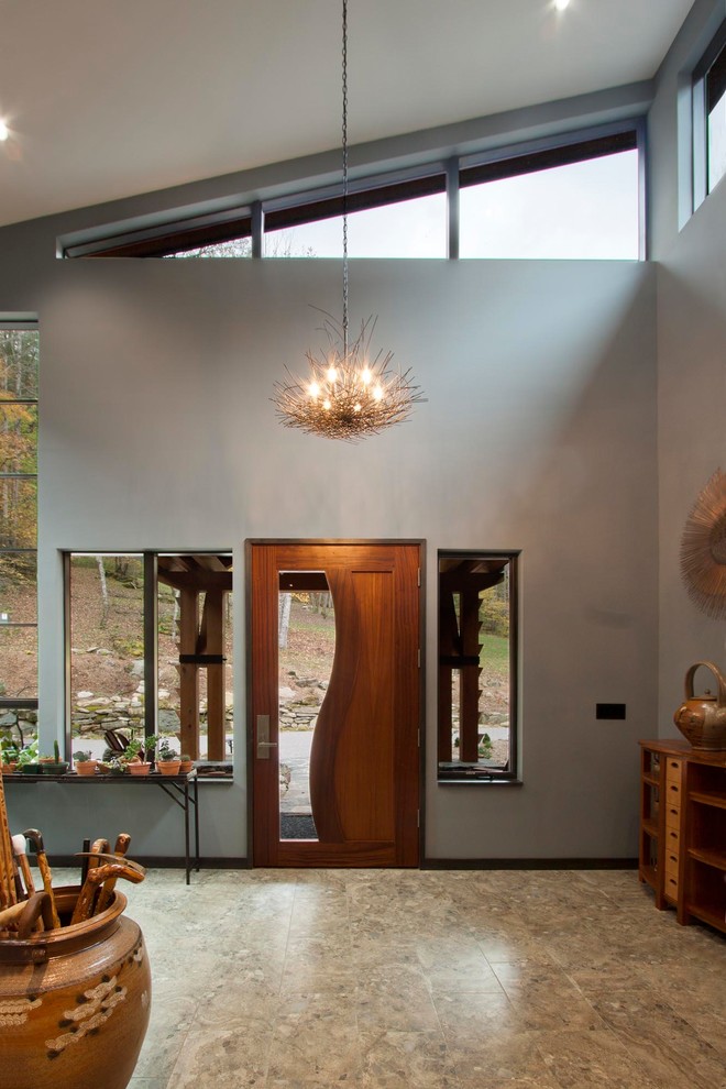 他の地域にある高級な広いコンテンポラリースタイルのおしゃれな玄関ロビー (木目調のドア、茶色い床、茶色い壁、磁器タイルの床) の写真