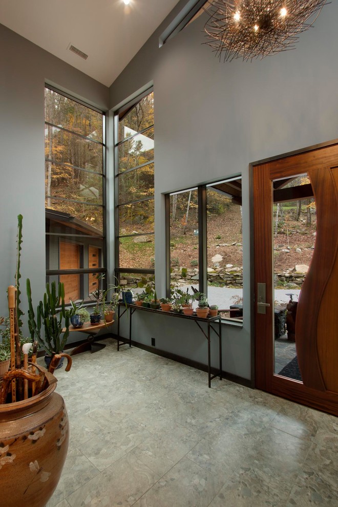 他の地域にある高級な広いコンテンポラリースタイルのおしゃれな玄関ロビー (木目調のドア、茶色い床、茶色い壁、磁器タイルの床) の写真