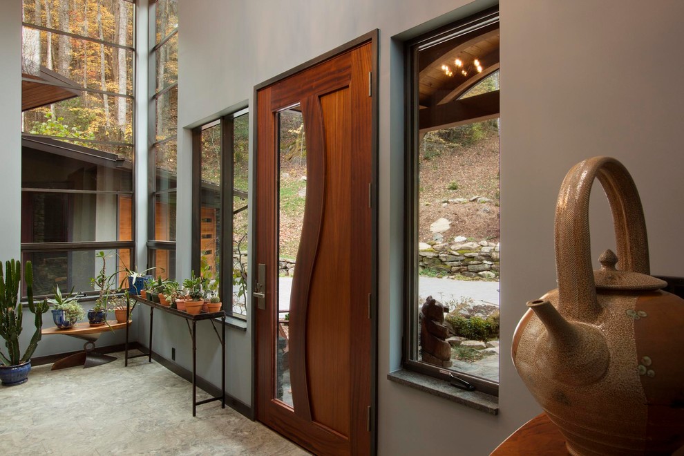 他の地域にある高級な広いコンテンポラリースタイルのおしゃれな玄関ロビー (磁器タイルの床、木目調のドア、茶色い床、茶色い壁) の写真