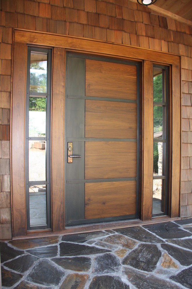 Imagen de puerta principal minimalista grande con paredes marrones, suelo de pizarra, puerta simple y puerta marrón