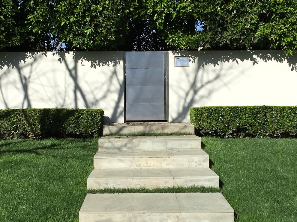 Immagine di un ingresso o corridoio minimalista di medie dimensioni con una porta singola e una porta in metallo