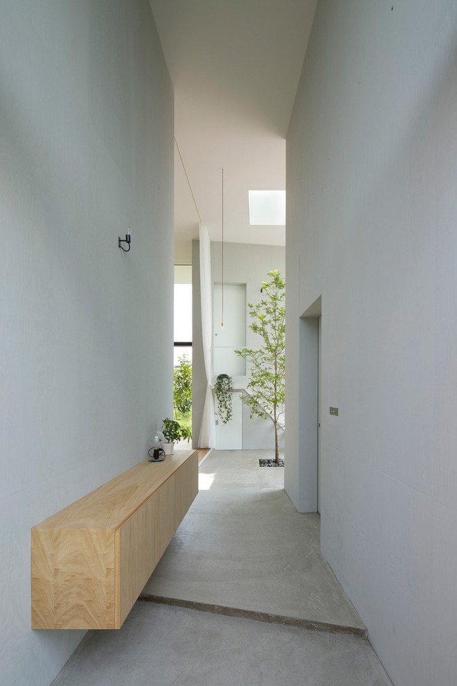 Inspiration for a large contemporary entrance in London with concrete flooring and white walls.