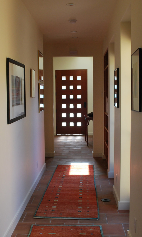 Imagen de hall actual con paredes beige, suelo de baldosas de terracota, puerta simple y puerta de madera oscura