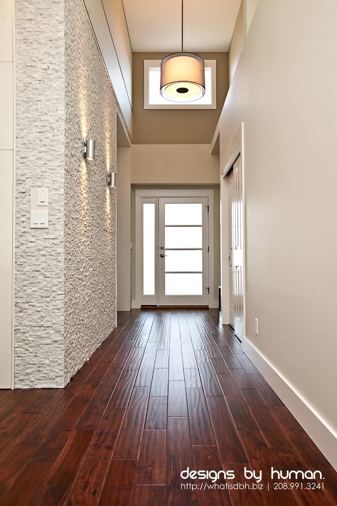 Idée de décoration pour une entrée design avec un couloir, parquet foncé, une porte simple et une porte blanche.