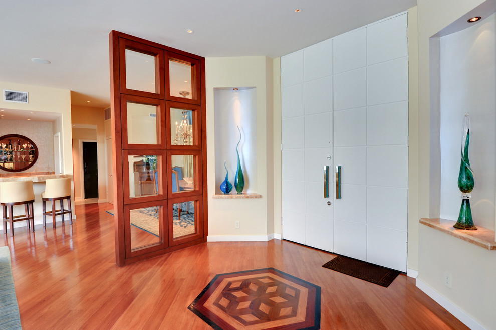 Inspiration for a mid-sized contemporary medium tone wood floor entryway remodel in Los Angeles with beige walls and a white front door