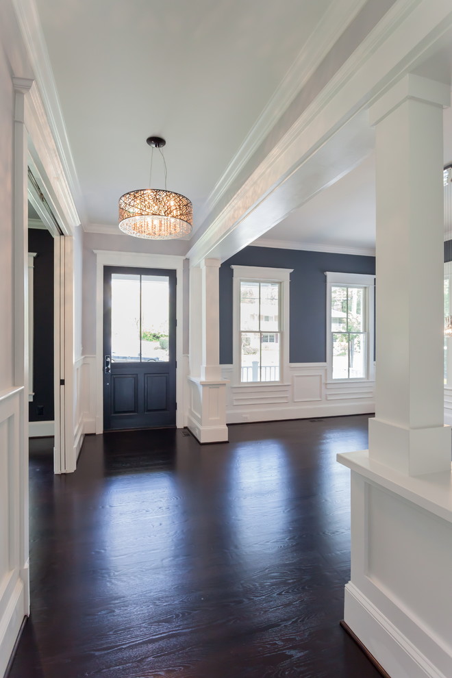 Klassisches Foyer mit beiger Wandfarbe, dunklem Holzboden, Einzeltür, dunkler Holzhaustür und braunem Boden in Washington, D.C.