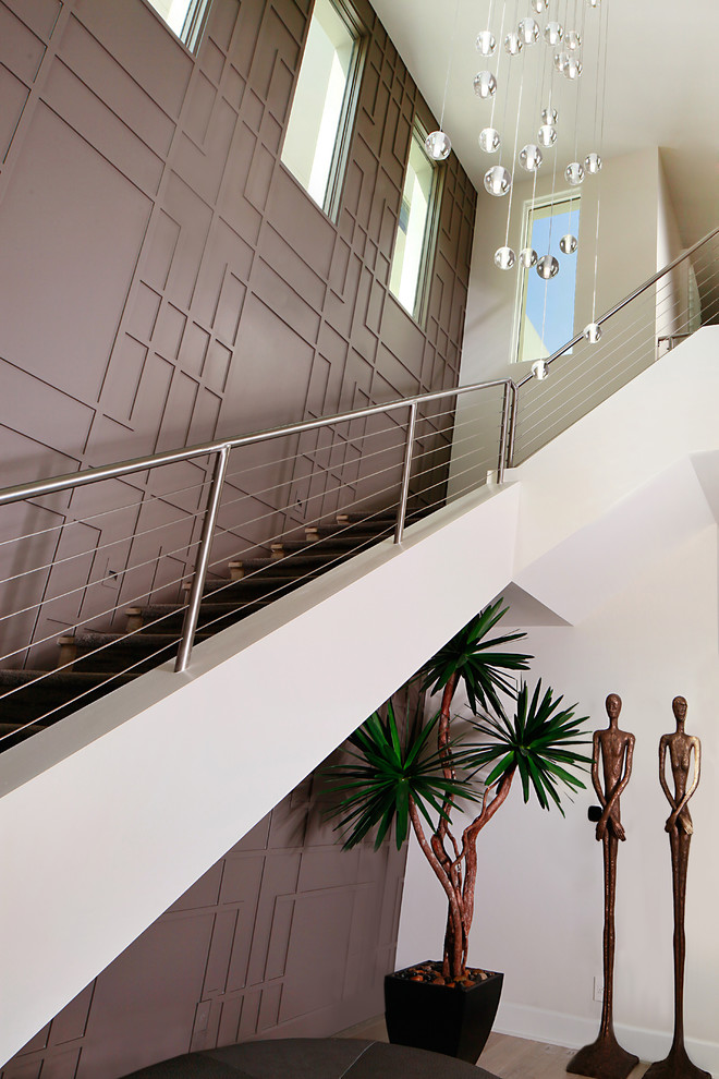 Cette image montre un grand hall d'entrée design avec un mur marron, parquet clair et un sol beige.