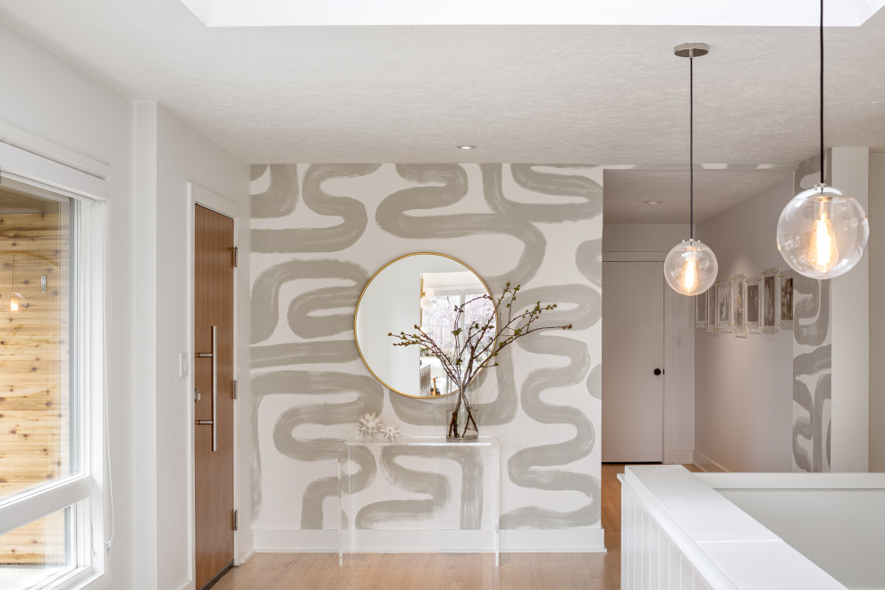 Ejemplo de entrada contemporánea con paredes blancas, suelo de madera en tonos medios, suelo marrón y papel pintado