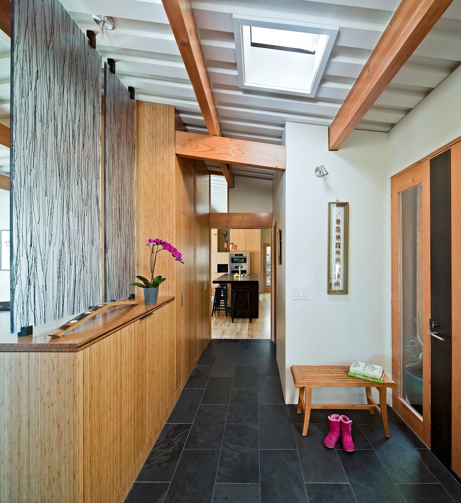 Ispirazione per un corridoio contemporaneo con pareti bianche, una porta singola e una porta in legno bruno