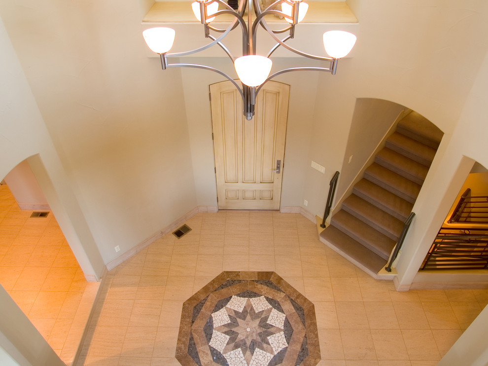 Example of a large trendy porcelain tile entryway design in Denver with white walls and a light wood front door
