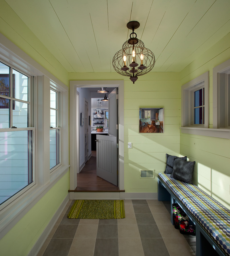Klassischer Eingang mit Stauraum, grüner Wandfarbe, Klöntür, grauer Haustür, buntem Boden, Holzdielendecke und Holzdielenwänden in Grand Rapids