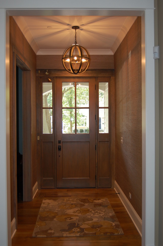 Стильный дизайн: маленькая входная дверь в стиле кантри с коричневыми стенами, паркетным полом среднего тона, одностворчатой входной дверью и входной дверью из темного дерева для на участке и в саду - последний тренд