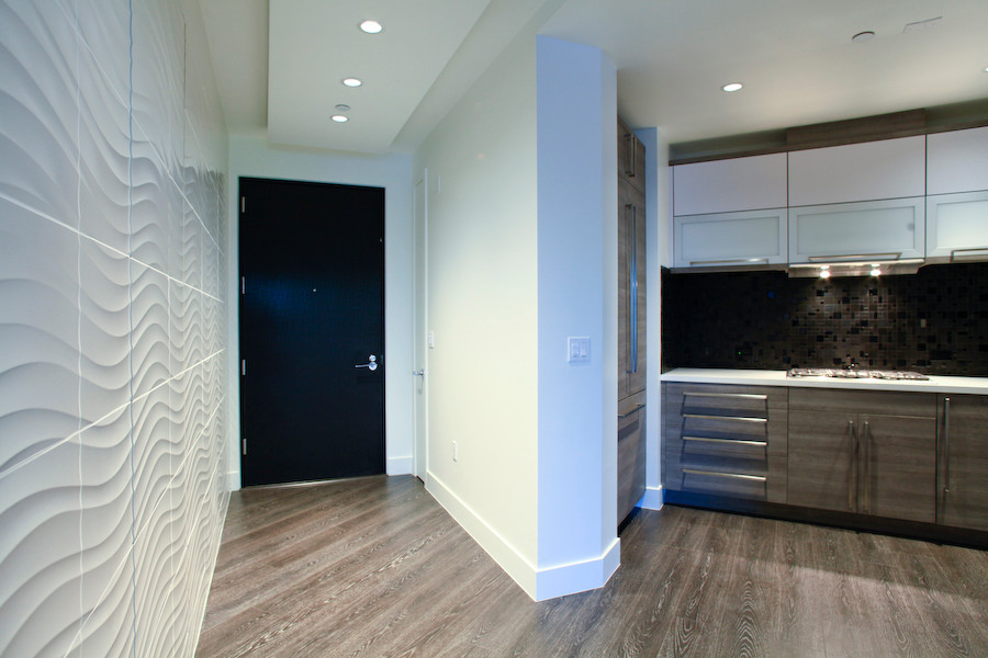 Photo of a contemporary foyer in Las Vegas with white walls, a single front door, a black front door and brown floors.
