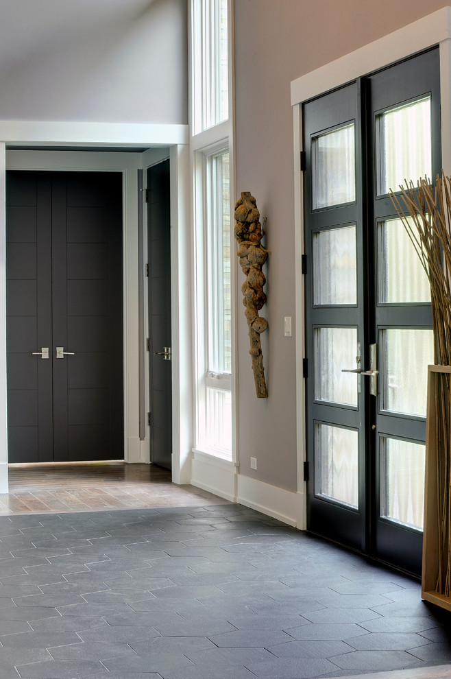 На фото: входная дверь в современном стиле с двустворчатой входной дверью и входной дверью из темного дерева с