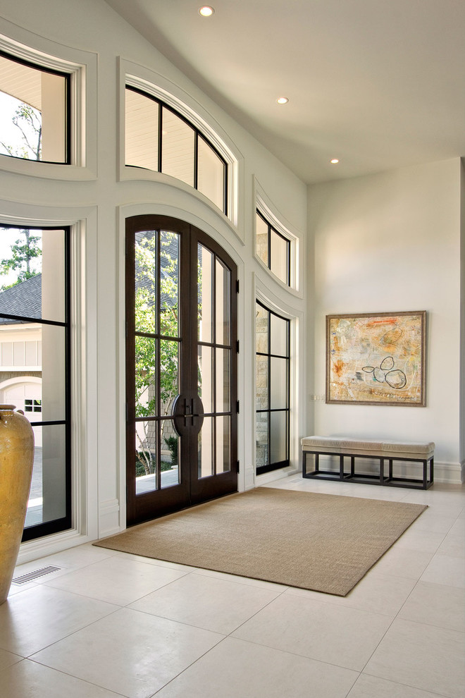 На фото: огромное фойе в современном стиле с белыми стенами, полом из керамической плитки, двустворчатой входной дверью и стеклянной входной дверью с
