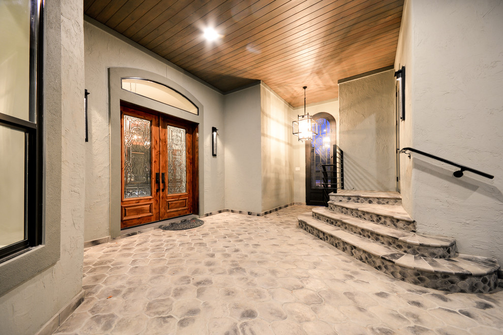 ヒューストンにあるラグジュアリーな広いコンテンポラリースタイルのおしゃれな玄関ドア (グレーの壁、ライムストーンの床、ガラスドア、グレーの床) の写真