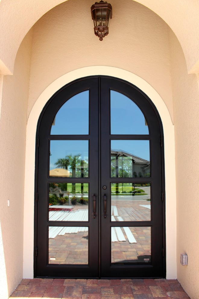 Cette image montre une grande porte d'entrée design avec une porte double et une porte métallisée.