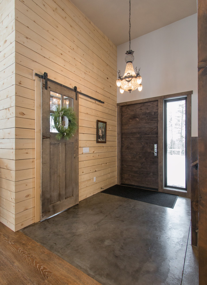 Esempio di un ingresso minimal di medie dimensioni con pareti bianche, pavimento in cemento, una porta singola e una porta in legno scuro