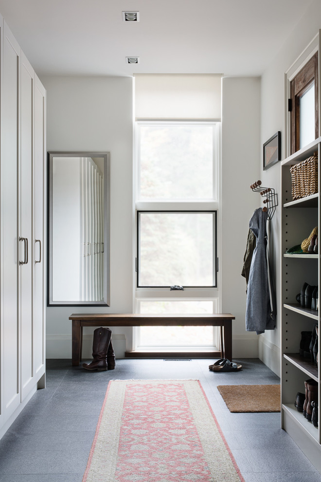 Inspiration pour une grande entrée design avec un vestiaire, un mur blanc, sol en granite, une porte simple et une porte en bois brun.
